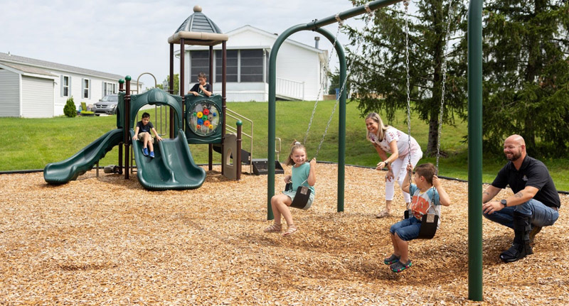 Families enjoying the playground at The Reserves family-friendly manufactured home community in Jackson Michigan